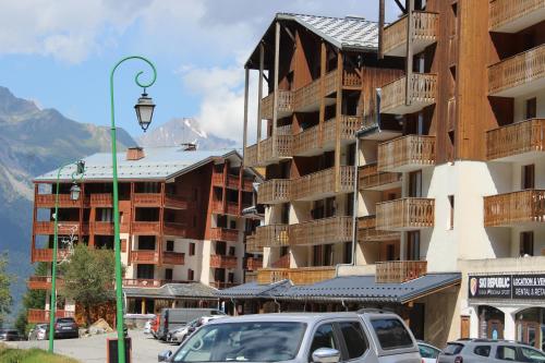 a parking lot in front of a large apartment building at Studio 4 personnes cœur station in Valfréjus
