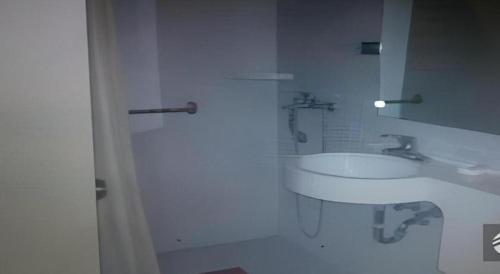 a white bathroom with a sink and a mirror at Jinjiang Inn Wuhu High-Speed Railway Station West Square in Wuhu
