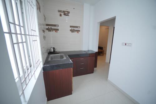 a small kitchen with a sink and a window at JR Service Apartment in Coimbatore
