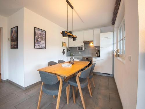 a kitchen and dining room with a wooden table and chairs at Apartment near the ski slope in Brixen in Feuring