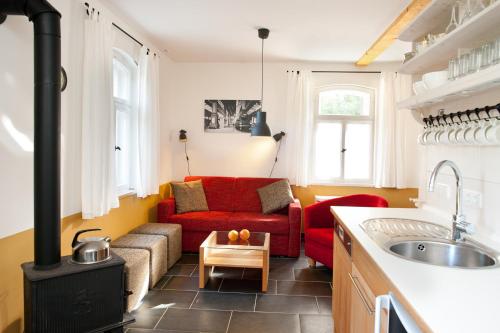 a living room with a red couch and a stove at Bahnwärterhaus in Droßdorf