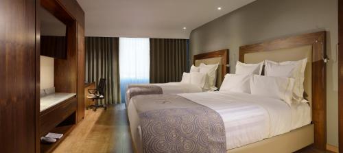 um quarto de hotel com duas camas com almofadas brancas em HS HOTSSON Hotel Silao em Silao