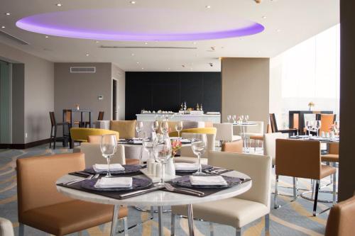 a dining room with a table with chairs and a purple ceiling at HS HOTSSON Hotel Silao in Silao