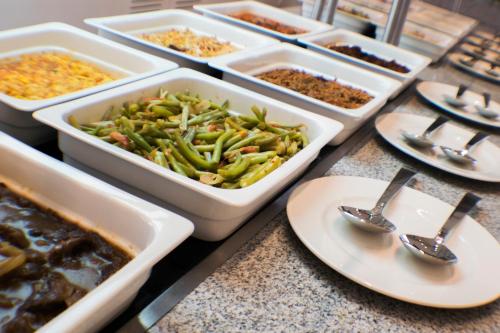 a buffet with several trays of food on a counter at HS HOTSSON Hotel Silao in Silao