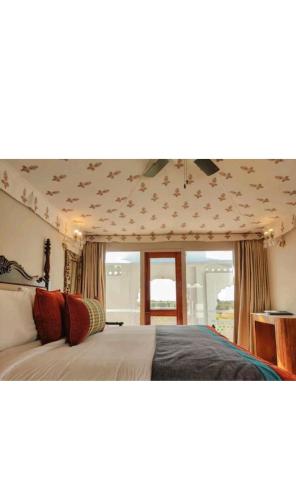 a bedroom with two beds and a large window at ThePalaceByParkJewels in Jaipur