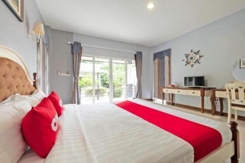 sypialnia z dużym łóżkiem z czerwonymi poduszkami w obiekcie OYO 75338 Winza Hotel and Resort w mieście Chanthaburi