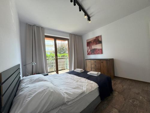 クラクフにあるPapaj apartment, supervision, garageのベッドと大きな窓のある寝室