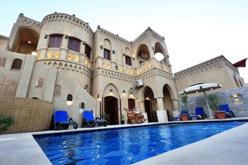 a house with a swimming pool in front of a building at Villa Nur in Luxor