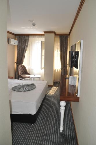 a hotel room with a bed and a chair at Grand Sera Hotel in Ankara