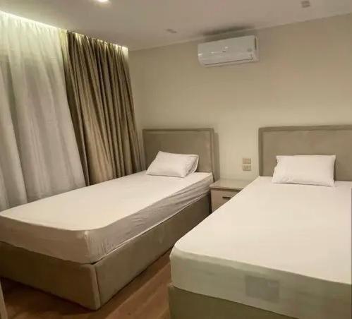 two twin beds in a room with at saudia jabooo in Dammam