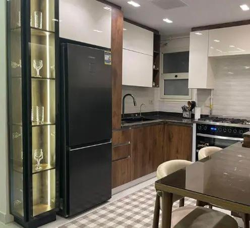 a kitchen with a black refrigerator and a table at saudia jabooo in Dammam
