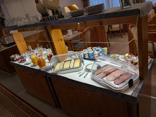 a table with sausage and other food on it at Hotel Park Eden in Bad Bellingen