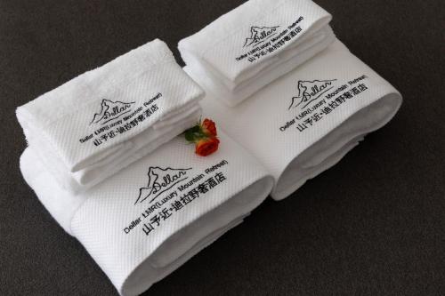 a pile of white towels with a strawberry on them at Shanyujin Dellar Wild Luxury Hotel Luxury Mountain Retreat in Lijiang
