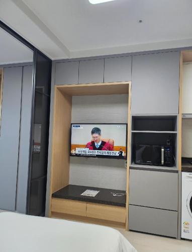 Habitación con TV en la pared en la cocina en 여수호텔 퍼스트시티 429호 더블 하프오션뷰, en Ungch'ŏn-ni