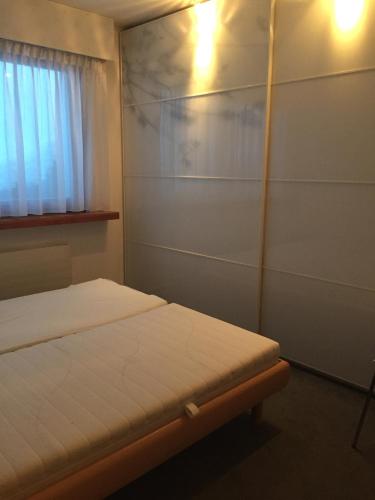 a small bedroom with a bed and a window at Roc d'Orsay E51 in Leysin