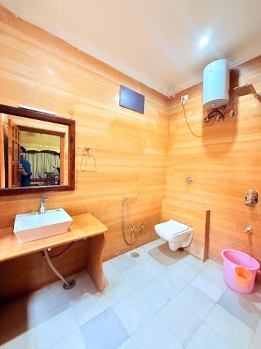 a bathroom with a sink and a toilet and a mirror at Wonbin Safari Jaisalmer in Jaisalmer