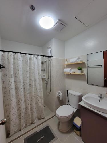 Un baño con inodoro y cortina de ducha en Dylan's Crib, en Bacolod