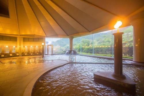 a room with a pool of water in a building at Yufuin Onsen Yufuin Nanairo no Kaze in Yufuin