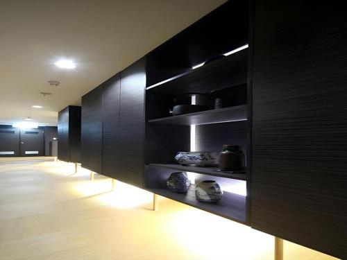 a room with black walls and shelves with pots on them at Suigetsurou Hotel in Takaoka