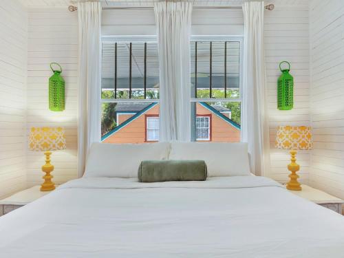 Un dormitorio con una cama blanca y una ventana. en Coast A While, en Tybee Island