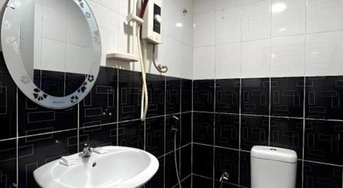 a bathroom with a sink and a mirror and a toilet at Ampang Point Star Hotel in Kuala Lumpur