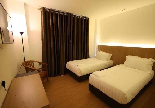 a hotel room with two beds and a window at Place2Stay @ RH Plaza Hotel in Kuching