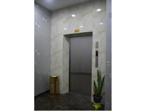 a elevator in a building with a door and a plant at ID Hotel Yayasan in Segamat