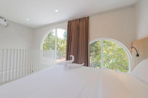 ein Schlafzimmer mit einem weißen Bett mit einem Schwan darauf in der Unterkunft 1BR Stylish Mezzanine Near In Dreamland in Uluwatu