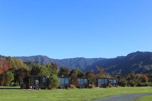 a view of a house with mountains in the background at The Barn Cabins & Camp in Marahau