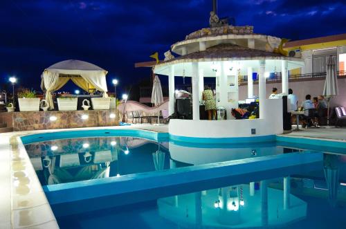 a pool at a resort at night at Guest House Dena in Dobra Voda