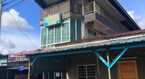 a building with a sign on top of it at OYO 90797 Napoh Motel 