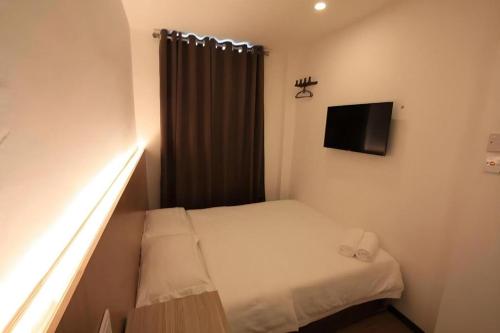a small room with a bed and a television at Place2stay @ Campus Hub in Kuching