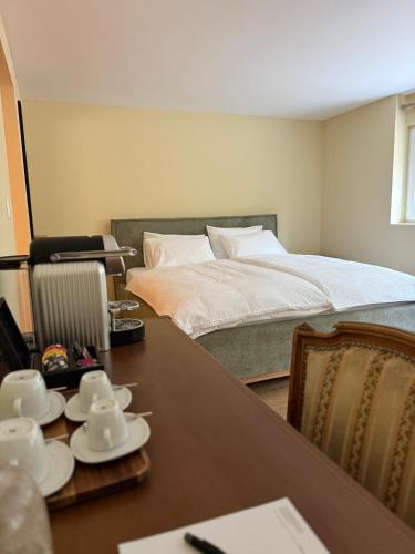 a room with a bed and a table with dishes on it at Rôtisserie in Saint-Maurice