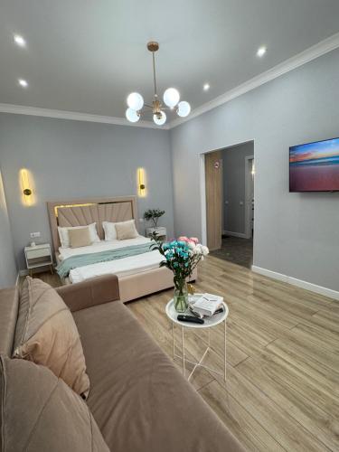 ein Wohnzimmer mit einer Couch und einem Bett in der Unterkunft ЖК Champion с новым ремонтом in Astana