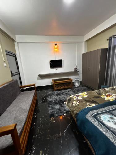 a room with two beds and a flat screen tv at Norkyi Homestay in Tawang