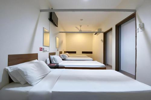 due letti in una camera d'albergo con due letti di SPOT ON 91178 Motel Impian a Seri Manjung