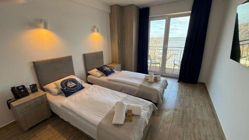 two beds in a hotel room with a balcony at Relax place & restaurant in Zegrze Południowe