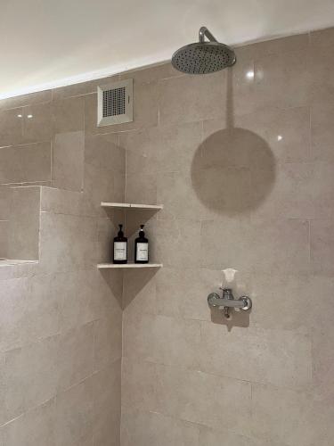 a bathroom with a shower with two bottles of wine at In Da Lodge in Ubud