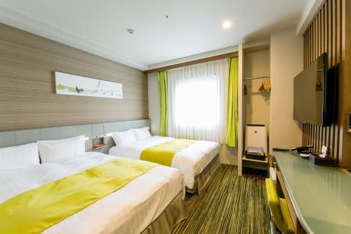 a hotel room with two beds and a television at Hotel Sardonyx Ueno in Tokyo