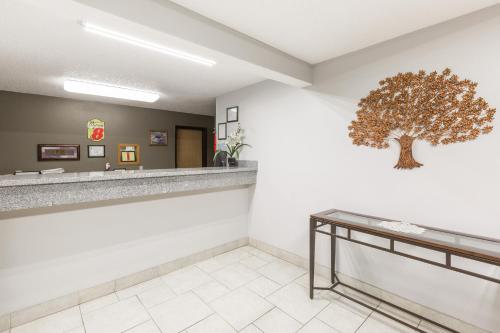 a waiting room with a tree on the wall at Super 8 by Wyndham Osceola IA in Osceola