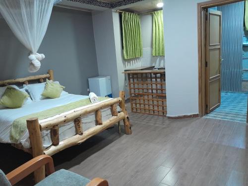 1 dormitorio con cama de madera y ventana en Ashara guesthouse, en Āwasa