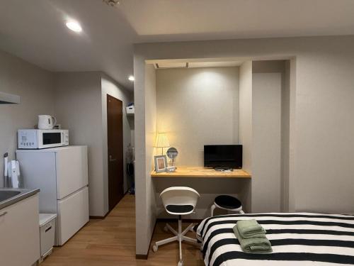 a small room with a bed and a desk with a computer at YY-Minamicho 1 room-IT0339 in Tokyo