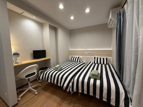 a bedroom with a black and white striped bed and a desk at YY-Minamicho 1 room-IT0339 in Tokyo