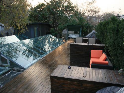 a deck with a bench and a chair on it at Kelly‘s Courtyard Hotel in Beijing