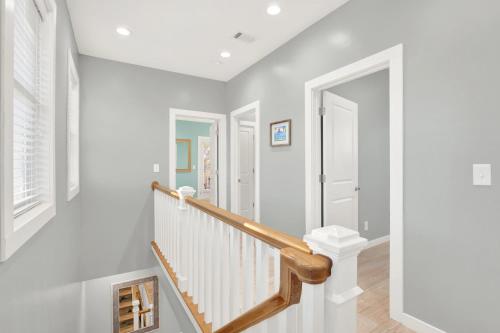 a white staircase in a home with white walls at Coastal Livin' in Tybee Island