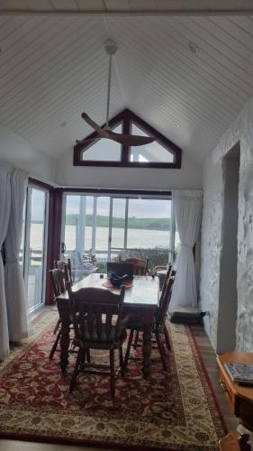 una sala da pranzo con tavolo, sedie e lampadario di Captains Cottage a Stanley
