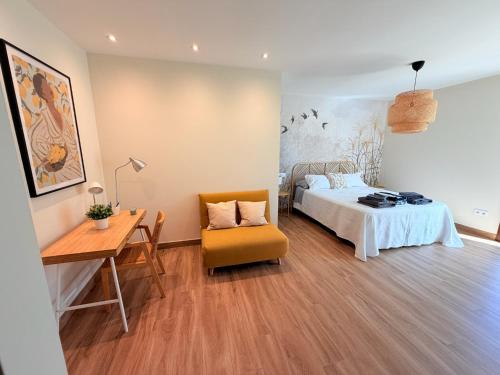 a bedroom with a bed and a desk and a chair at El Legado de Gredos in Candeleda
