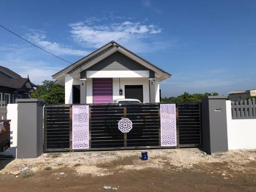 ein Haus mit einem Tor davor in der Unterkunft Casa Amethyst in Kuala Terengganu