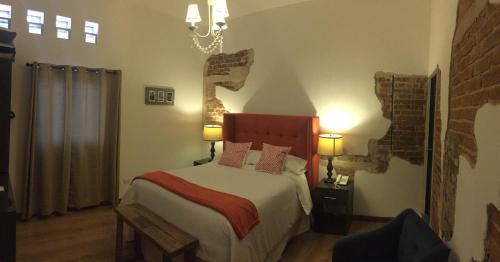 a bedroom with a bed and a chandelier at Meraki Boutique Hotel in Guatemala