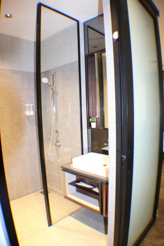 a bathroom with a shower and a sink in a mirror at Hospitality Service Suites Scarlitz KLCC in Kuala Lumpur
